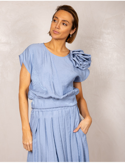 Blauwe top met bloemdetail op de schouder